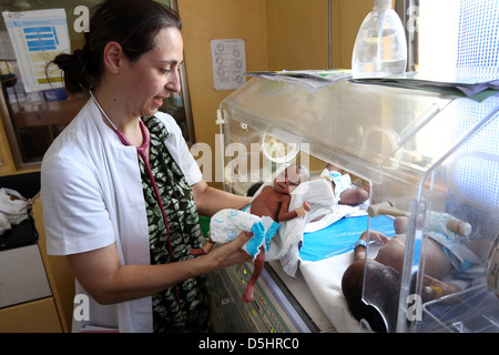 female german doctor examining newborn african babies in incubator. Hospital in Techiman, Ghana Stock Photo