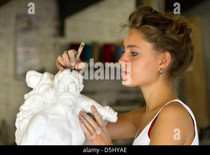 20-year old apprentice sculptor Ada Koesler, daughter of German sculptor Frank Koesler, works on a smaller sized statue of Hercules, a reproduction of the original statue from Berlin's city palace, in her father's workshop in Berlin, Germany, 29 August 2012. Photo: Patrick Pleul Stock Photo