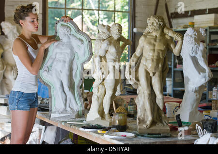 20-year old apprentice sculptor Ada Koesler, daughter of German sculptor Frank Koesler, works on a smaller sized statue of Hercules, a reproduction of the original statue from Berlin's city palace, in her father's workshop in Berlin, Germany, 29 August 2012. Photo: Patrick Pleul Stock Photo