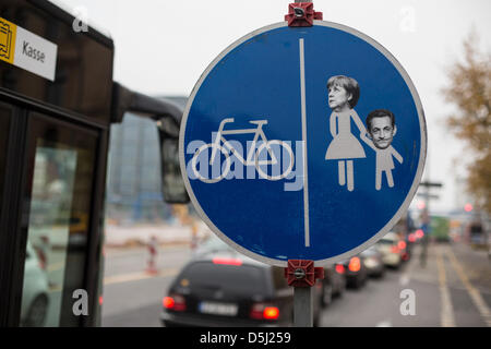 A traffic sign with the heads of German chancellor Angela Merkel and France's former president Nicolas Sarkozy is pictured at a cycling path in Berlin, Germany, 12 November 2012. It is a remainder of Merkel's closeness to Sarkozy which brought her the nick name Merkozy. Photo: Hannibal Stock Photo