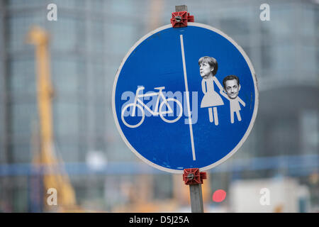A traffic sign with the heads of German chancellor Angela Merkel and France's former president Nicolas Sarkozy is pictured at a cycling path in Berlin, Germany, 12 November 2012. It is a remainder of Merkel's closeness to Sarkozy which brought her the nick name Merkozy. Photo: Hannibal Stock Photo