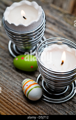 Easter candles on wooden table with egg decorations Stock Photo