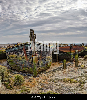 Hoo marshes with a derelict boats looking out to the river Medway Kent Stock Photo