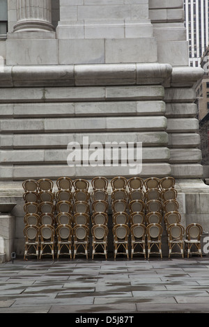 Stacked cafe chairs at Bryant Park behind the New York Public Library in Manhattan Stock Photo