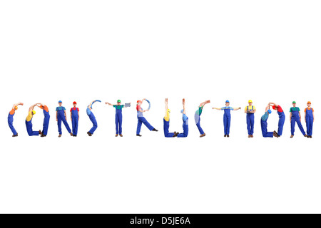 Group of young people wearing different color uniforms and hard hats forming Construction word - isolated on white background Stock Photo