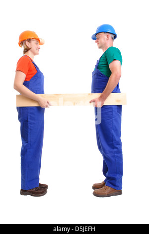 Female and male builders wearing jumpsuits and helmets holding wooden plank - over white background Stock Photo