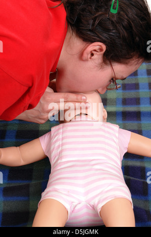 First aid instructor demonstrating artificial respiration using infant dummy Stock Photo