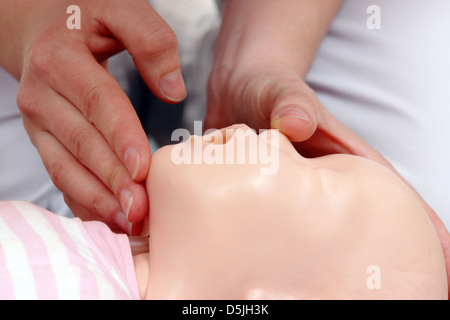 First aid instructor showing how to position infant head before proceeding to mouth-to-mouth resuscitation Stock Photo