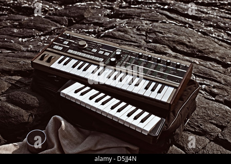 Music synthesizer lying on rocks close up Stock Photo