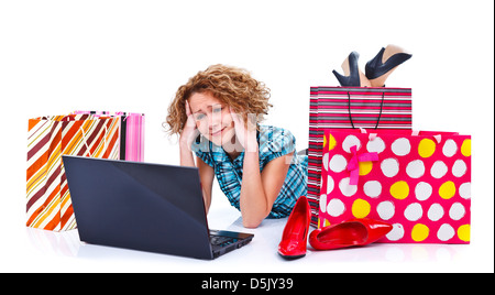 Young exhausted woman lying on the floor in front of laptop and shopping bags isolated over white background Stock Photo