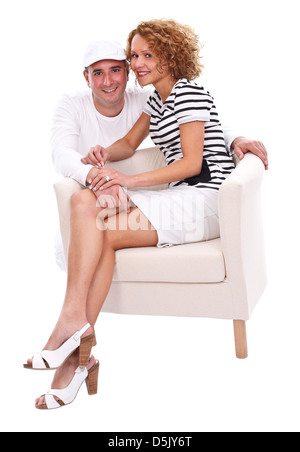 Young smiling couple sitting on armchair over white background Stock Photo