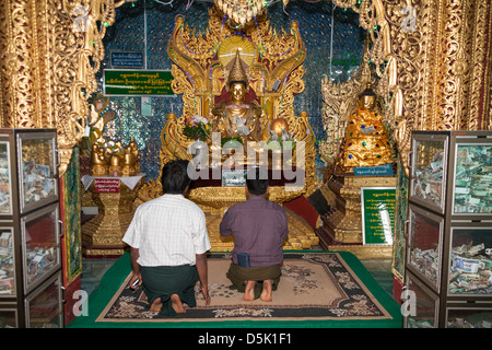 Worshippers praying inside Popa Taung Kalat Temple, Mount Popa, near Bagan, Myanmar, (Burma) Stock Photo