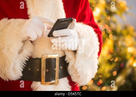 Santa claus holding cell phone Stock Photo