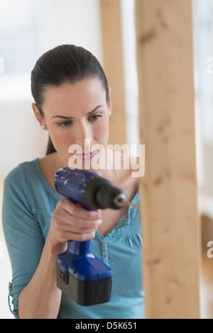 Woman using hand drill Stock Photo
