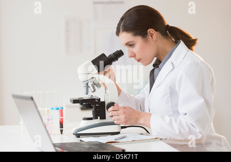 Scientist looking through microscope Stock Photo