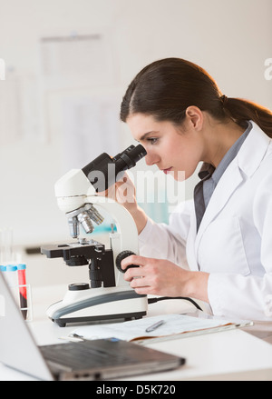 Scientist looking through microscope Stock Photo