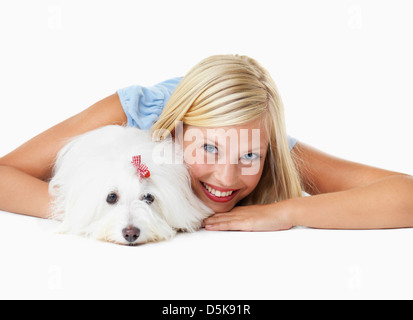 Studio Shot, Portrait of young woman lying down with het dog Stock Photo