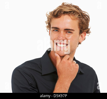 Studio Shot, Portrait of young man with hand on chin Stock Photo