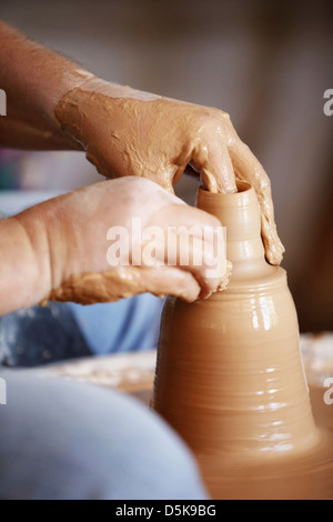 Hands working with clay on potter's wheel Stock Photo