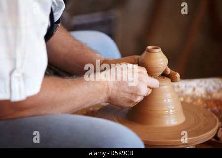 Hands working with clay on potter's wheel Stock Photo