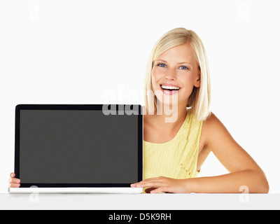 Studio portrait of young woman holding new laptop Stock Photo