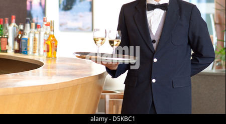 A waiter holding a tray with white wine glasses for serving Stock Photo
