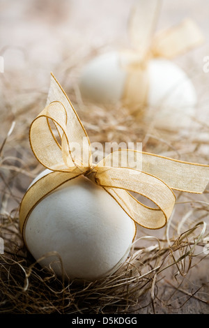 White easter eggs with beautiful golden bow Stock Photo