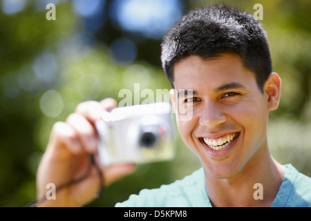 Portrait of young man using digital camera Stock Photo
