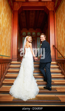 Young couple standing on steps in hallway Stock Photo