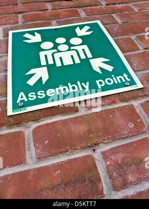 Assembly point sign on a wall. Stock Photo