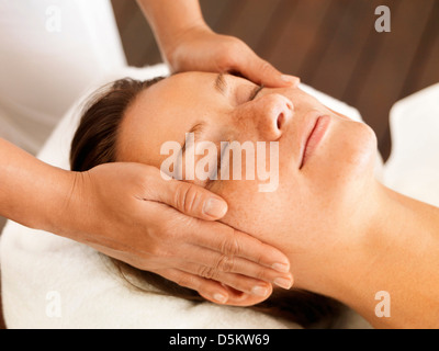 Woman getting facial massage in spa Stock Photo