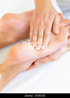 Hand massaging feet Stock Photo
