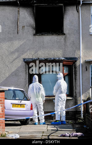 Fire investigation officers begin their examination of a fatal house fire. Stock Photo