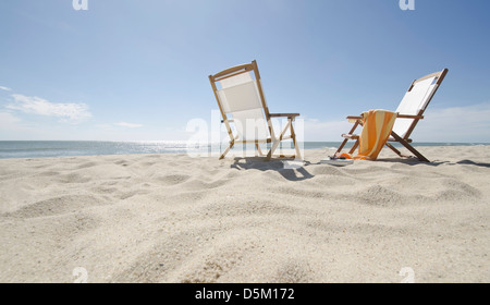 Sun chairs on sandy beach Stock Photo