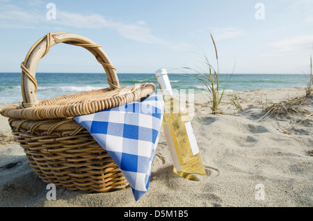 Picnic basket and white wine on beach Stock Photo