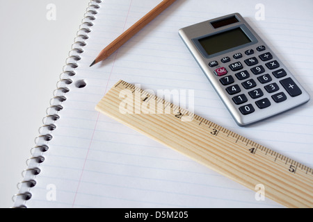 Calculator, ruler and pencil on notebook, studio shot Stock Photo