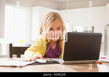 Blonde girl (6-7) using laptop Stock Photo