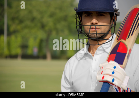 Portrait of cricketer holding a bat Stock Photo