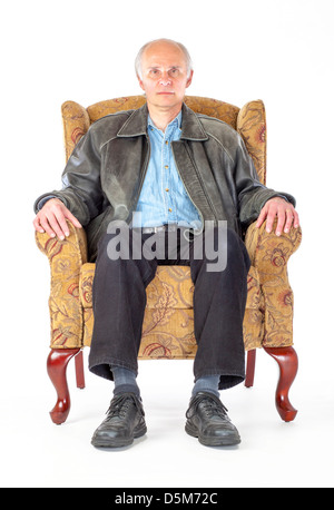 A middle aged man sits in a chair. Stock Photo