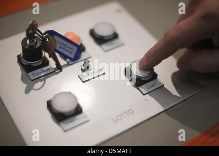 (FILE) An archive photo dated 25 April 2012 shows a finger pressing the start button of the lotto machine shortly before the drawing of the lotto numbers for the 30 year Wednesday lotto broadcast by ZDF German broadcasters in Mainz, Germany. After the unusual defect during the drawing of lotto numbers on Wednesday, 03 April 2013, the question has been raised as to the cause. Photo: Fredrik von Erichsen Stock Photo