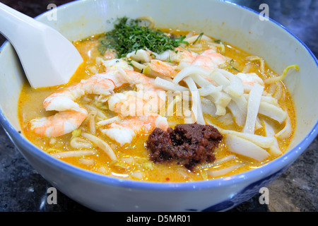 Singapore Curry Laska with Prawns Fishcake and Sambal Chili Paste Garnished with Daun Kesom Leaves Macro Stock Photo