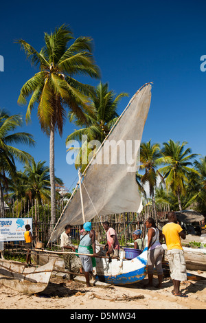 Madagascar, Nosy Be, Ambatoloaka, fisherman dragging boat up beach Stock Photo