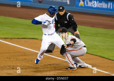 03.04.2013. Los Angeles, California, USA.  Los Angeles Dodgers left fielder Carl Crawford (25) jumps back to first to beat the tag of San Francisco Giants 1st baseman Buster Posey (28) during the Major League Baseball game between the Los Angeles Dodgers and the San Francisco Giants at Dodger Stadium in Los Angels, CA. The Giants defeated the Dodgers 5-3. Stock Photo