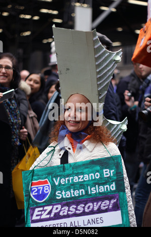 A woman wearing a model of a New York City bridge as a hat in New York City's Easter Parade Stock Photo