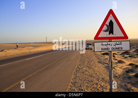 Sand Dunes sign with road and 4x4 in the middle of the desert in Oman on Route 35 - the 'Dunes highway' Stock Photo