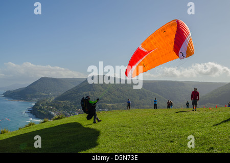 Hang gliding enthusiasts take the the skies creating a graceful spectacle at Stanwell Tops, Australia. Stock Photo