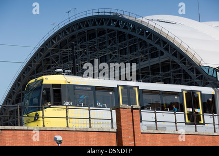 Yellow Metrolink tram in Manchester city centre Northern England UK passing Manchester Central exhibition centre Stock Photo