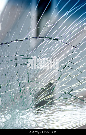 Looking through a smashed windscreen at the side of a blue house. Stock Photo