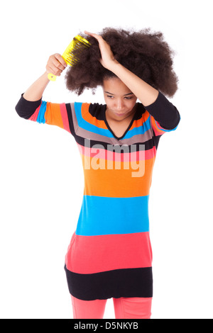 Black African American teenage girl combing her afro hair, isolated on white background Stock Photo