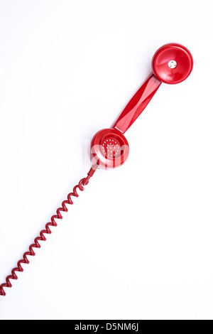 Red retro style telephone receiver and cord. Stock Photo